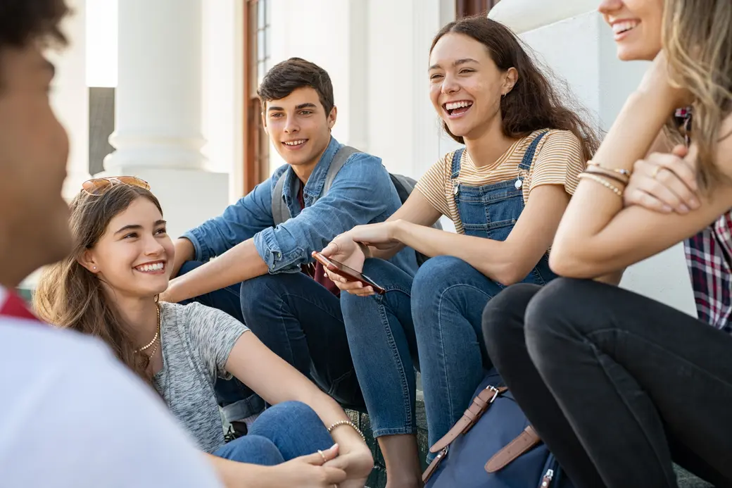 Teenager-Freunde sitzen zusammen und lachen